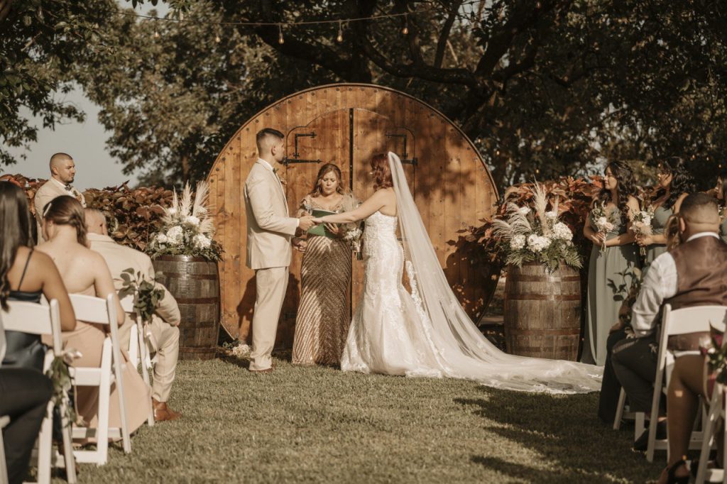 Bride and groom by wine barrels — outdoor wedding venues Florida with vineyard-inspired style.